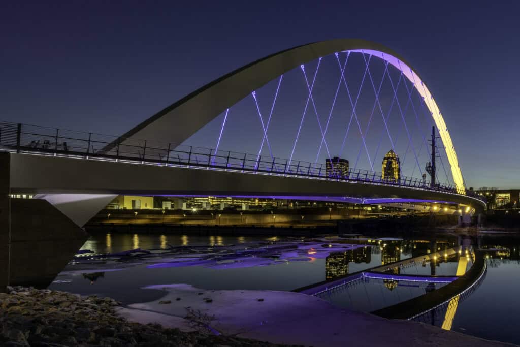 a suspension Bridge in Des Moines, Iowa - illuminated at night, symbolizing bridging gaps or connections or contact